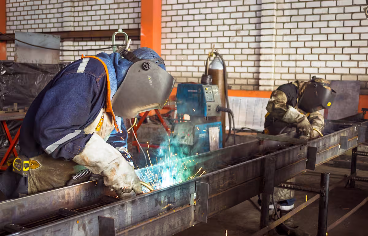 Trabajadores de taller soldando una estructura de acero